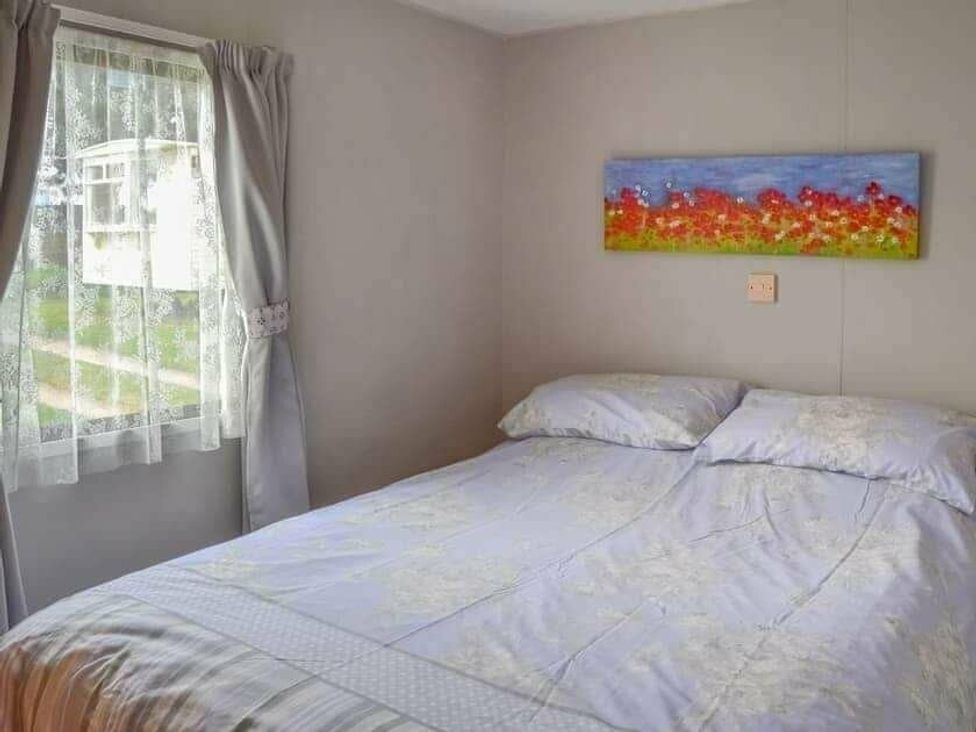 a bedroom with a double bed and a painting on the wall at Beach Haven Caravan Park - Holiday Accommodation 16700, Bacton