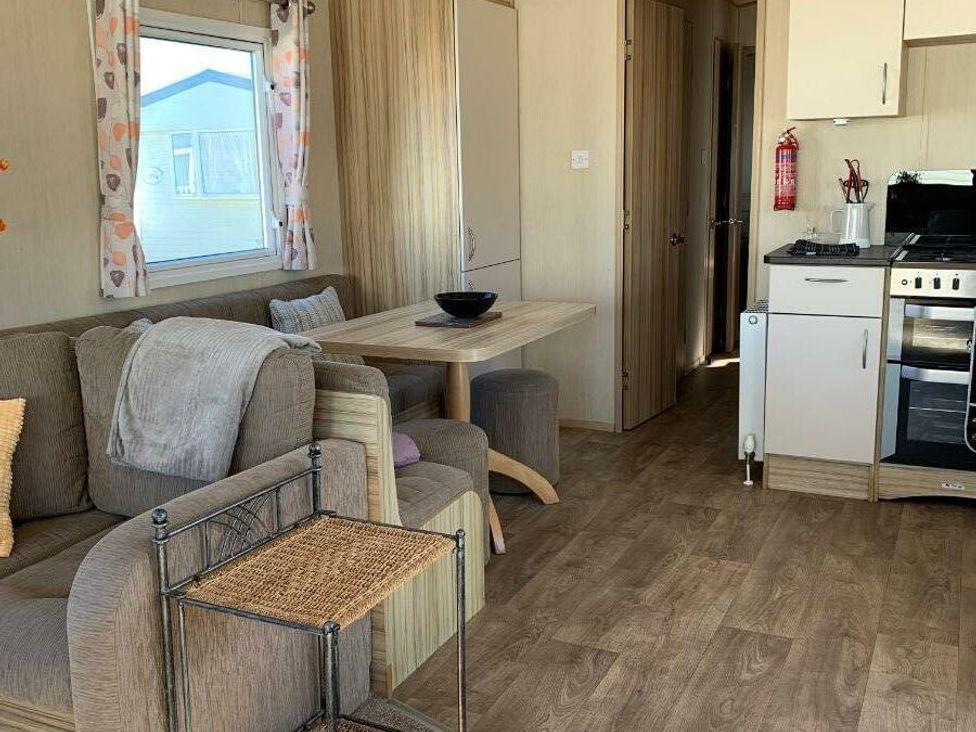 a living room with a couch and a table in Alberta Holiday Park - Holiday Accommodation 16770, Whitstable