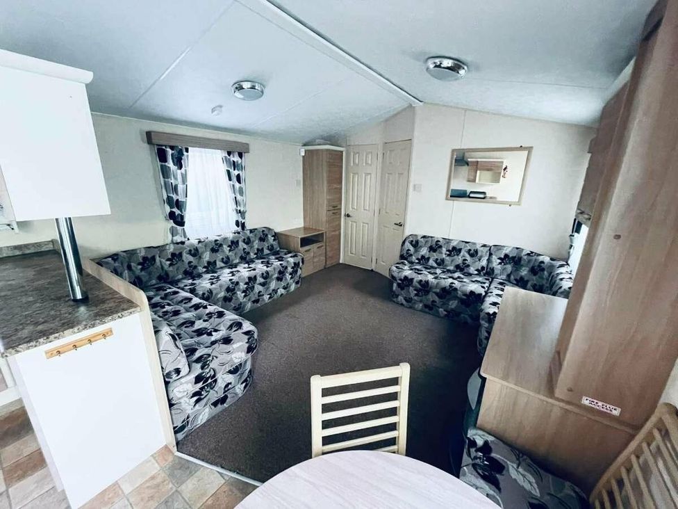 a living room with patterned sofas and a dining table at WigBay Holiday Park - Holiday Accommodation 16774 Stranraer