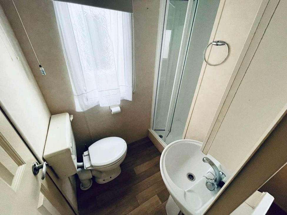 a bathroom with a toilet, sink, and shower cubicle at WigBay Holiday Park - Holiday Accommodation 16774, Stranraer
