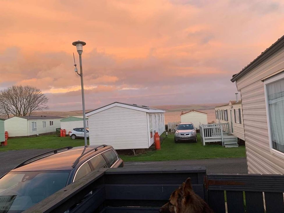 a view with mobile homes and a sunset at WigBay Holiday Park - Holiday Accommodation 16774 Stranraer