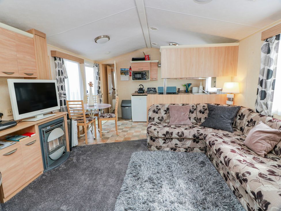 A living room with a sofa and dining area at WigBay Holiday Park - Holiday Accommodation 16774, Stranraer