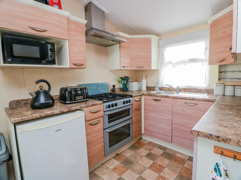A kitchen with appliances including a microwave, kettle, toaster, and oven at WigBay Holiday Park - Holiday Accommodation 16774, Stranraer
