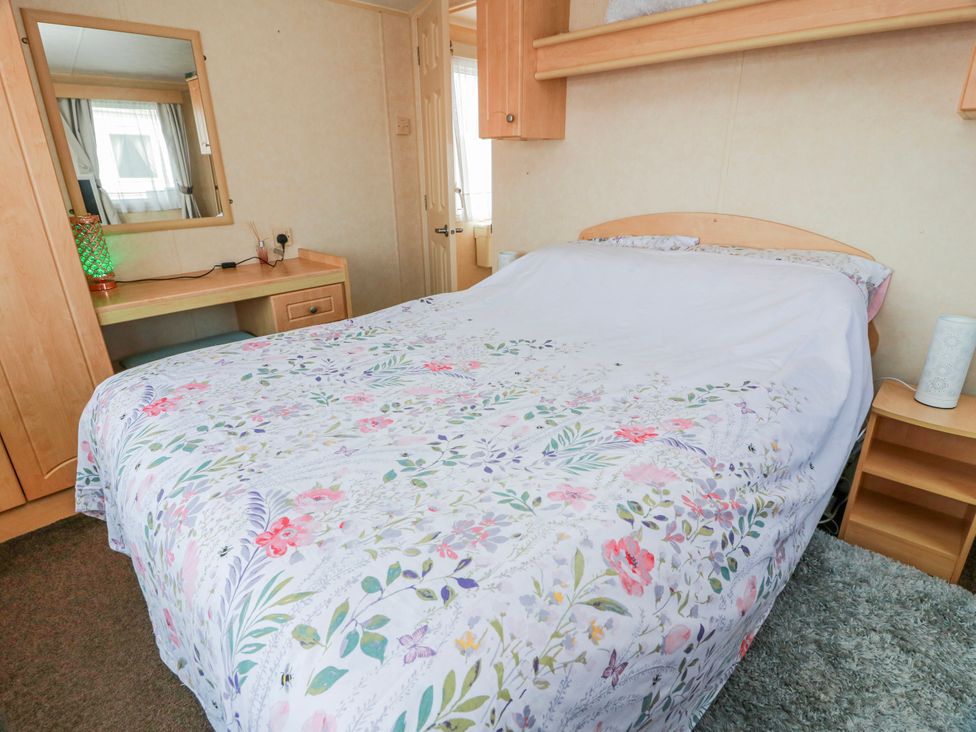 A bedroom with a bed and desk at WigBay Holiday Park - Holiday Accommodation 16774 Stranraer