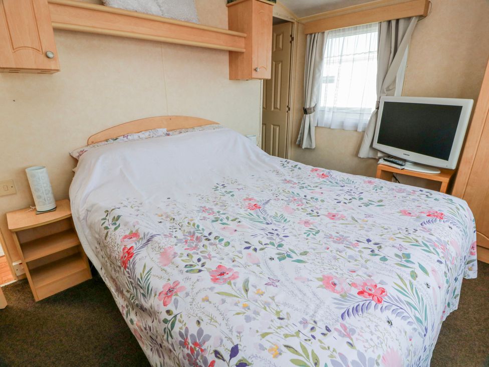 A bedroom with a double bed and a television at WigBay Holiday Park - Holiday Accommodation 16774 in Stranraer
