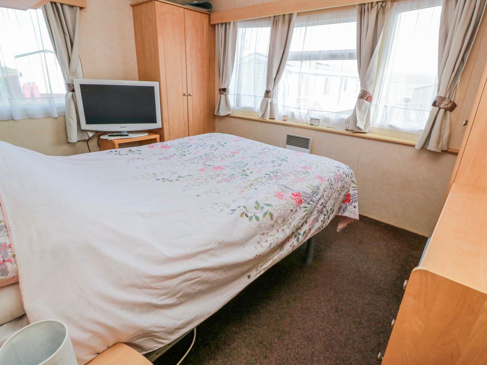 A bedroom with a bed and television at WigBay Holiday Park - Holiday Accommodation 16774, Stranraer