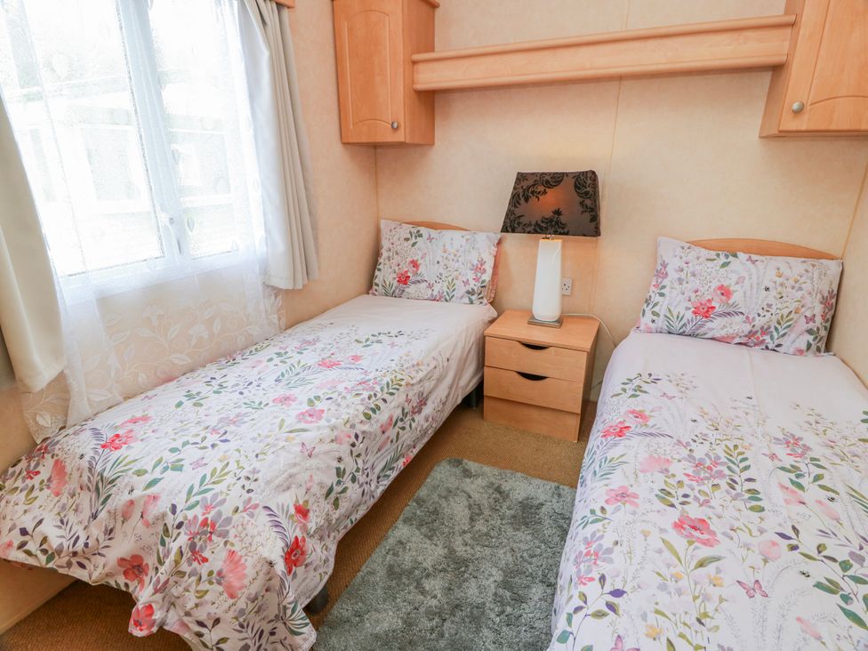 A bedroom with two beds and a lamp at WigBay Holiday Park - Holiday Accommodation 16774 Stranraer