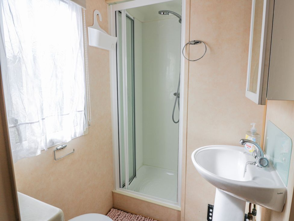 A bathroom with a shower and sink at WigBay Holiday Park - Holiday Accommodation 16774, Stranraer