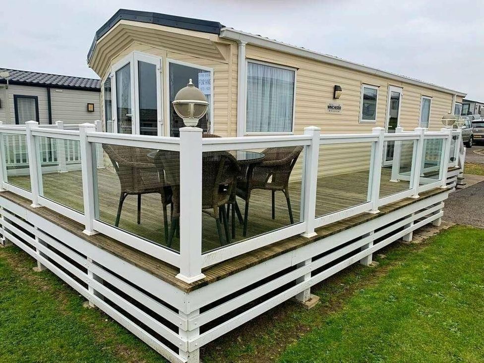 a holiday home with a deck and outdoor furniture at Chesil Beach Holiday Park - Holiday Accommodation 16933, Weymouth