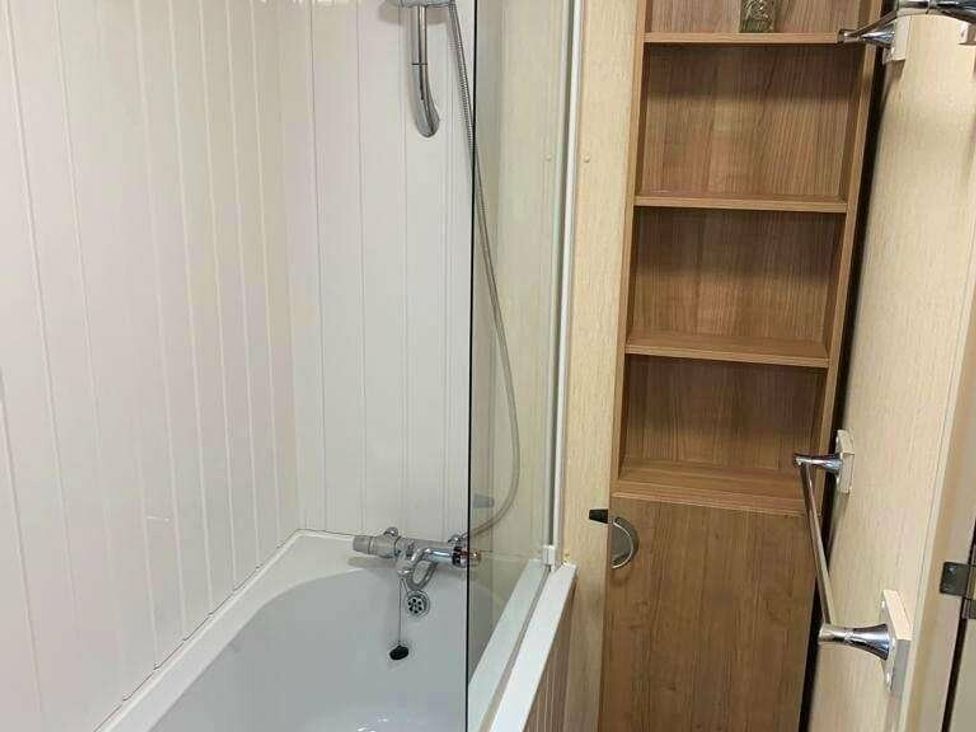 a bathroom with a bathtub and a shower enclosure at Chesil Beach Holiday Park - Holiday Accommodation 16933 in Weymouth