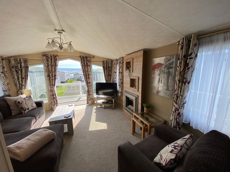 A living room with a television and sofa at Chesil Beach Holiday Park - Holiday Accommodation 16933 in Weymouth