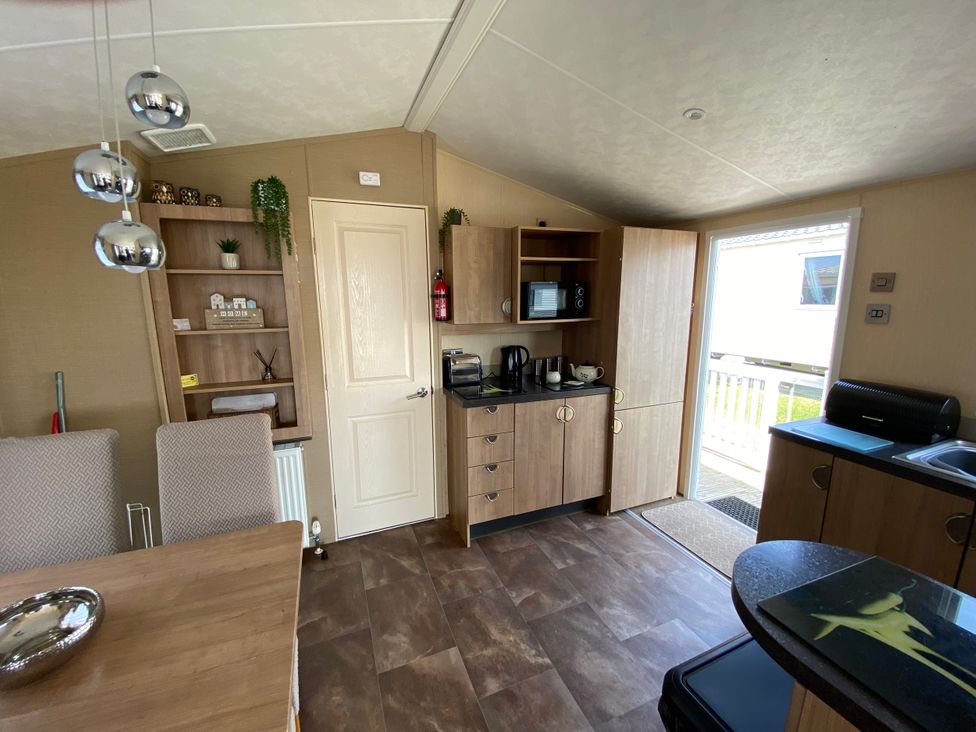 A kitchen with a counter and appliances at Chesil Beach Holiday Park - Holiday Accommodation 16933 in Weymouth