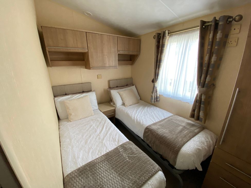 A bedroom with two single beds at Chesil Beach Holiday Park - Holiday Accommodation 16933 in Weymouth