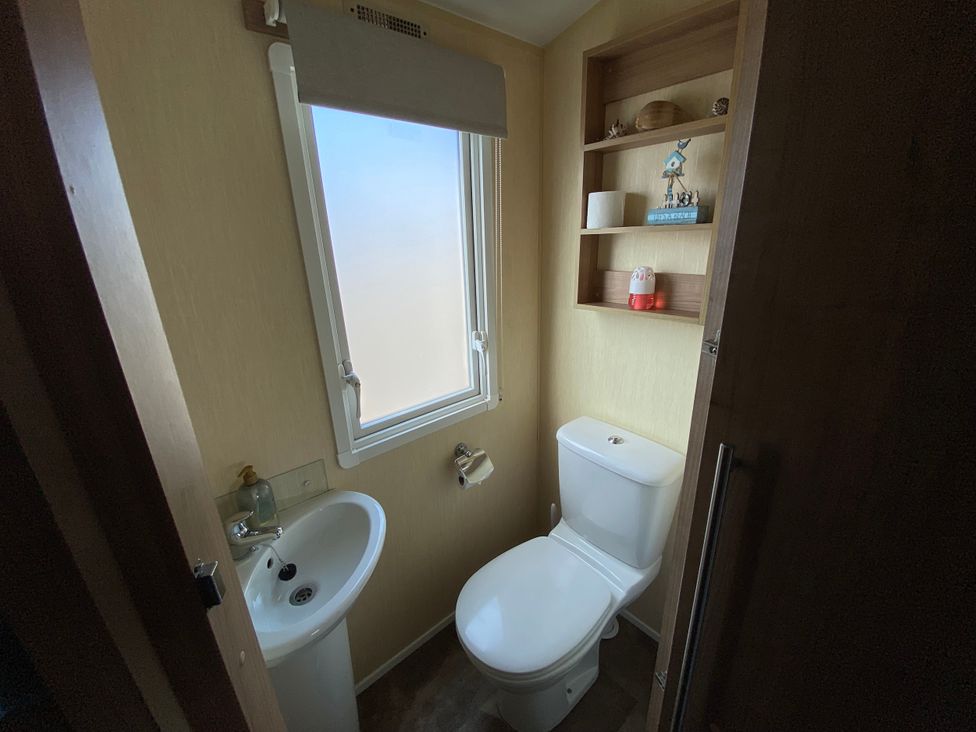 A bathroom with a toilet and sink at Chesil Beach Holiday Park - Holiday Accommodation 16933, Weymouth