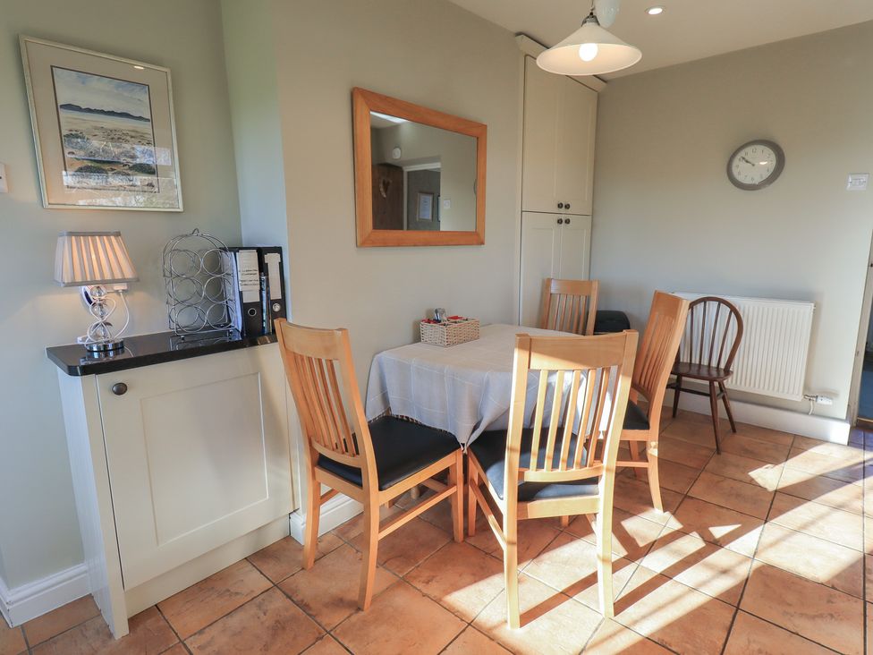 A dining room with a table and chairs at 2 Lupton Hall Cottages in Carnforth