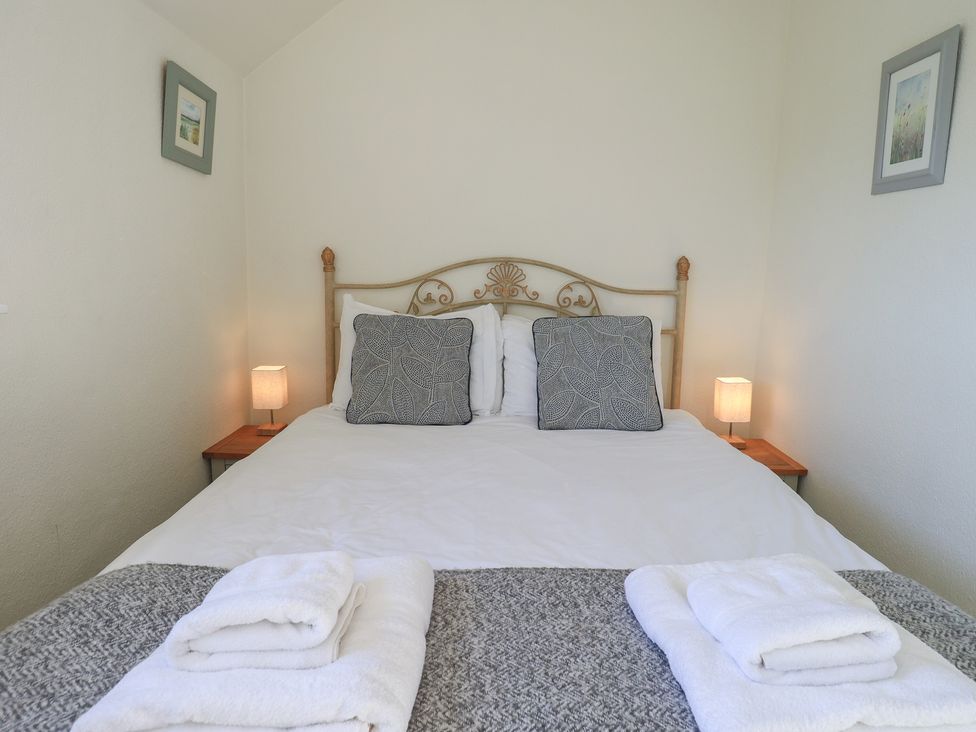 A bedroom with a bed and bedside tables at 2 Lupton Hall Cottages in Carnforth