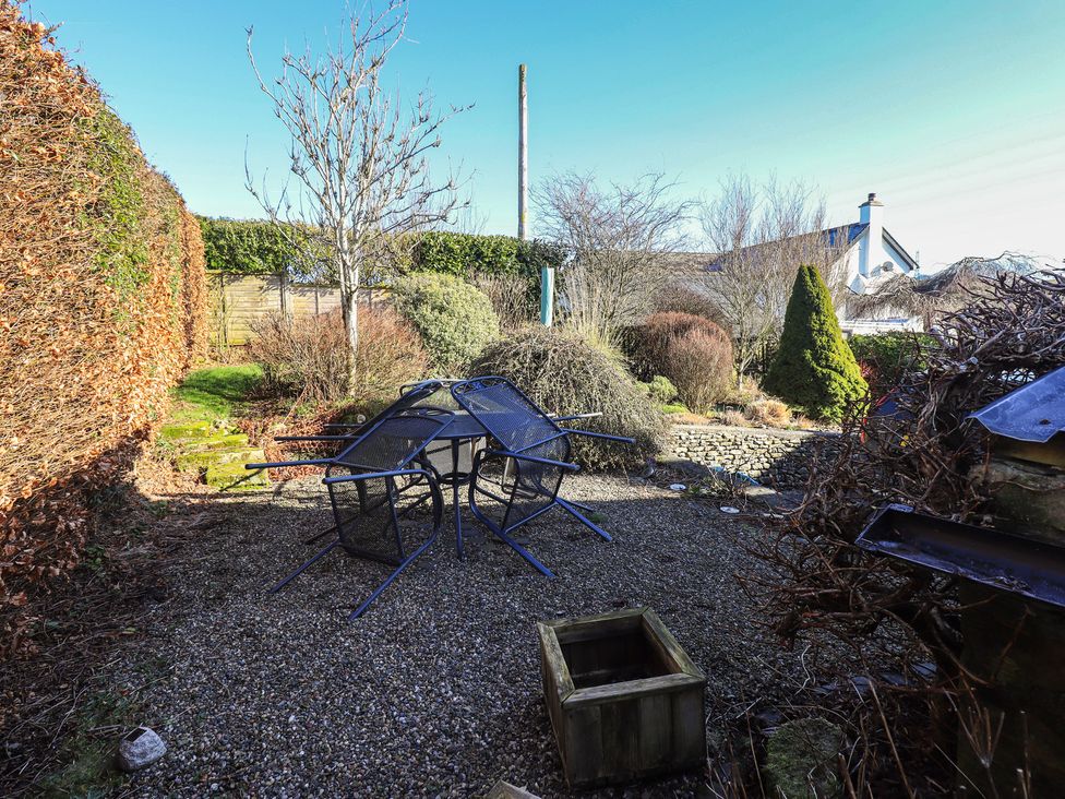 A garden with chairs and a table at 2 Lupton Hall Cottages, Carnforth
