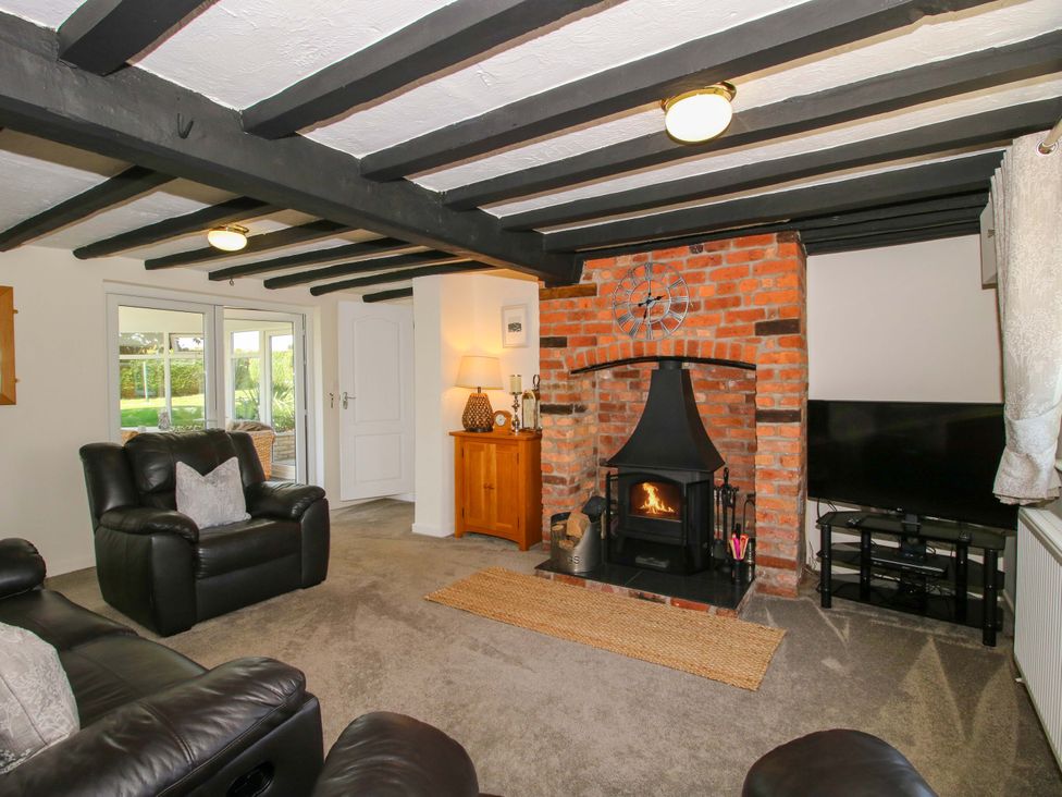 A living room with a fireplace and sofa at Fron-Haul near Llansantffraidd-Ym-Mechain