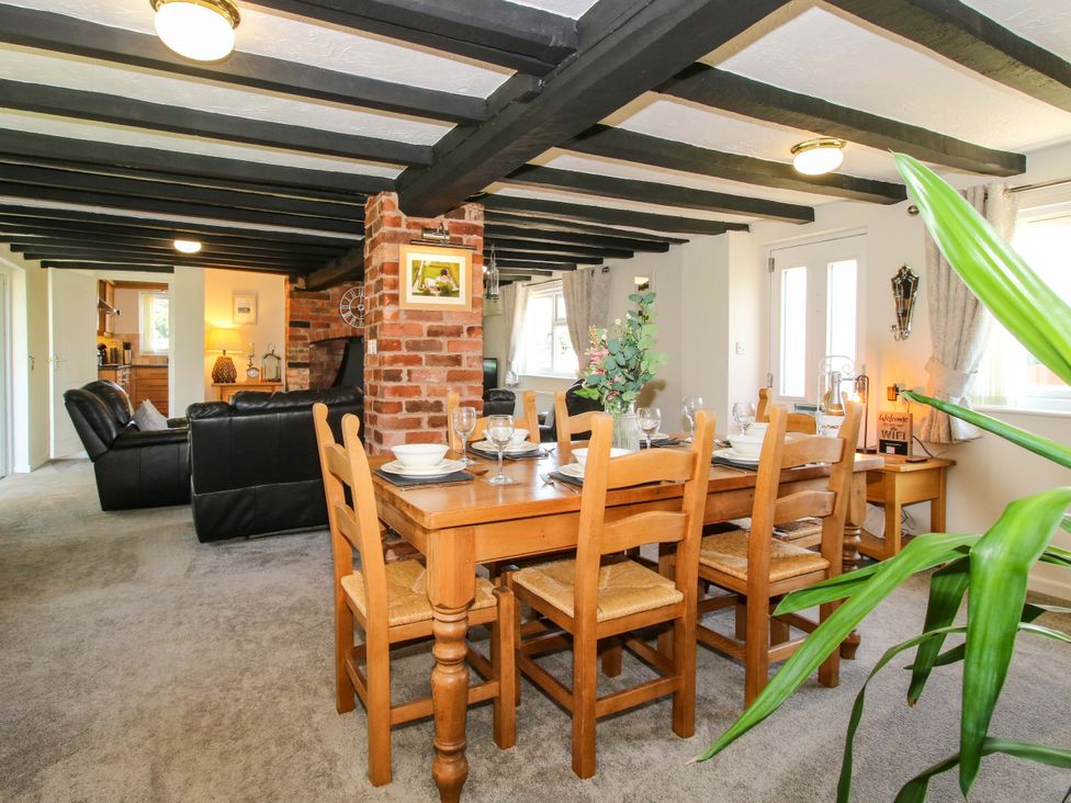 A dining area with a table and chairs at Fron-Haul Near Llansantffraidd-Ym-Mechain