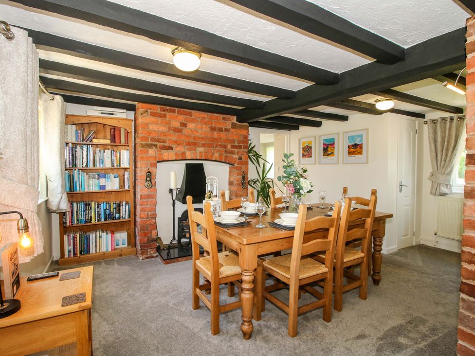 A dining room with a table and chairs at Fron-Haul near Llansantffraidd-Ym-Mechain