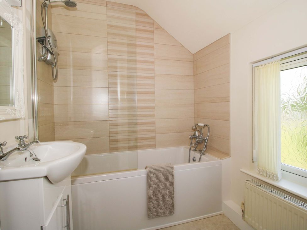 A bathroom with a bathtub and shower at Fron-Haul near Llansantffraidd-Ym-Mechain