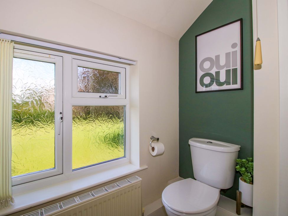A bathroom featuring a toilet and a window at Fron-Haul near Llansantffraidd-Ym-Mechain
