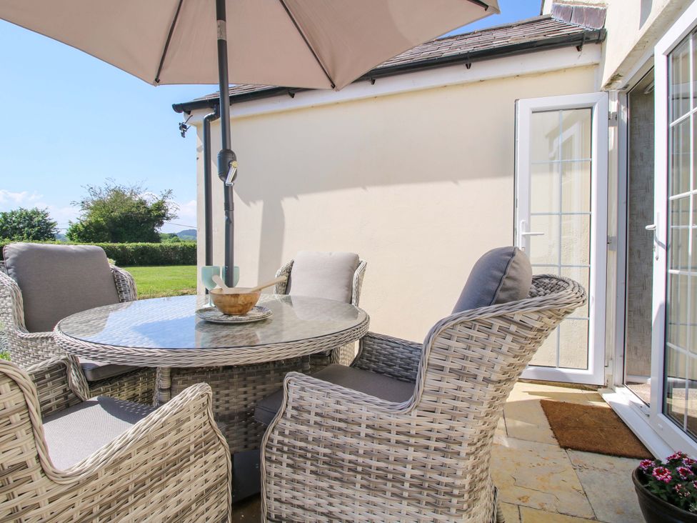 An outdoor seating area with a table and chairs at Fron-Haul near Llansantffraidd-Ym-Mechain