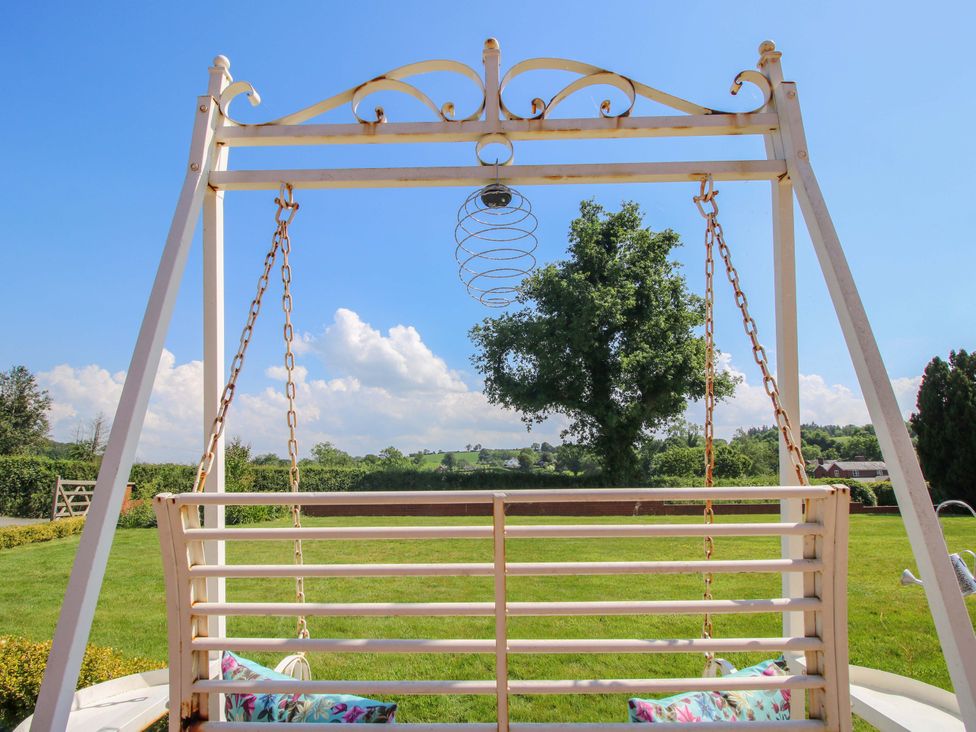 A swing with chains in a garden at Fron-Haul Near Llansantffraidd-Ym-Mechain