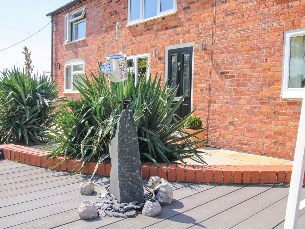 An outdoor area with plants and a decorative stone feature at Fron-Haul near Llansantffraidd-Ym-Mechain