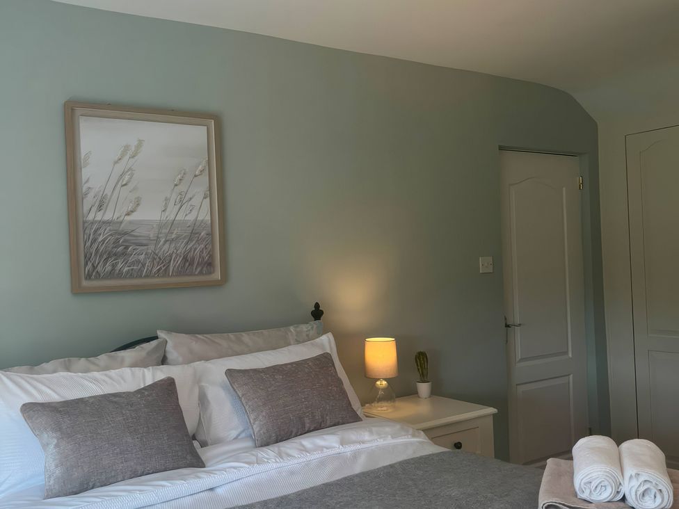 A bedroom with a bed and picture on the wall at Fron-Haul Near Llansantffraid-Ym-Mechain