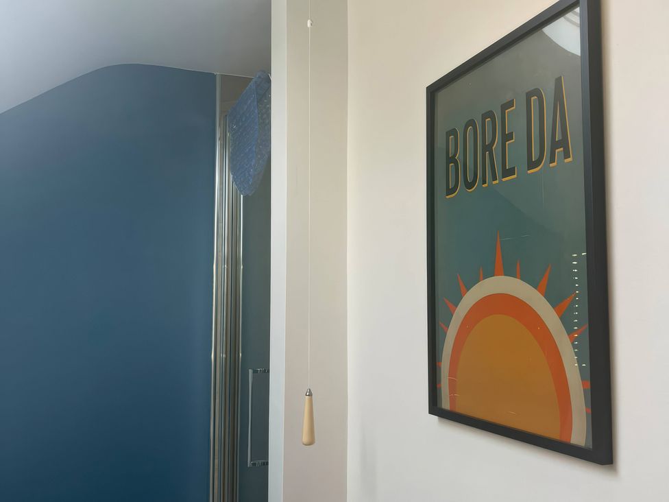 A bathroom with a poster and shower door at Fron-Haul near Llansantffraid-Ym-Mechain