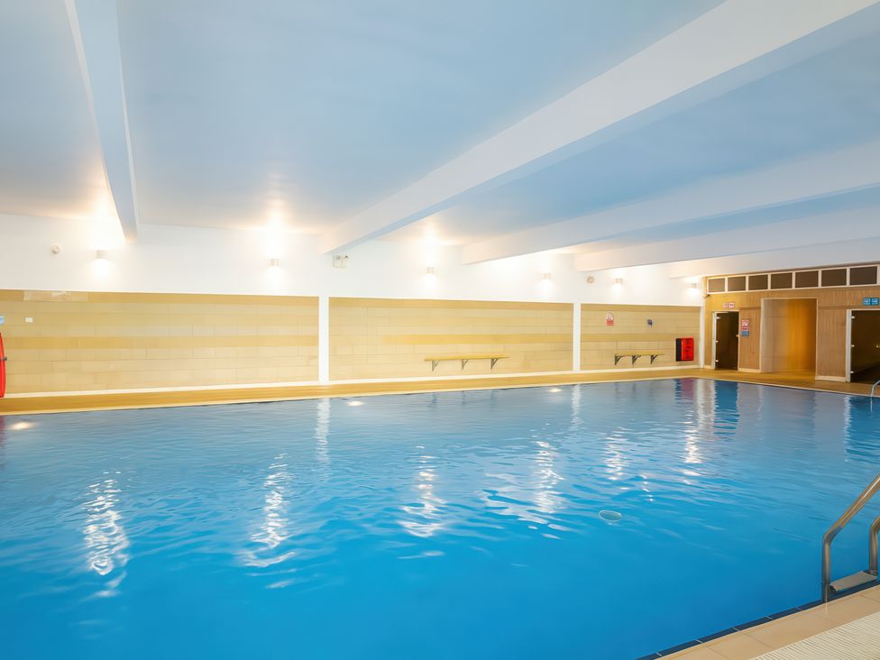 An indoor swimming pool with tile walls and changing room at Freshwater Beach Holiday Park - Holiday Accommodation 17116 Burton Bradstock near Bridport