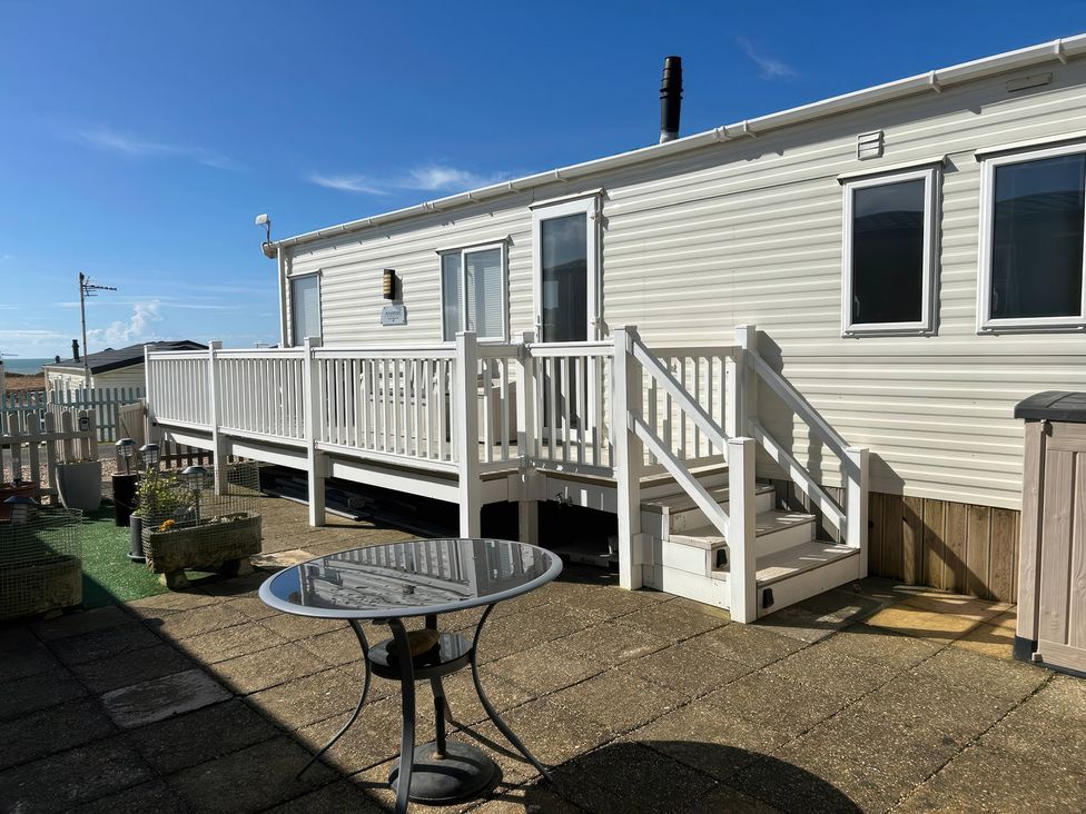 An outdoor area with a caravan and a table at Freshwater Beach Holiday Park - Holiday Accommodation 17116 Burton Bradstock near Bridport