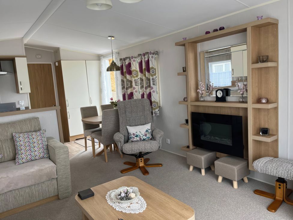 A living room with a dining table and chairs at Freshwater Beach Holiday Park - Holiday Accommodation 17116 Burton Bradstock near Bridport