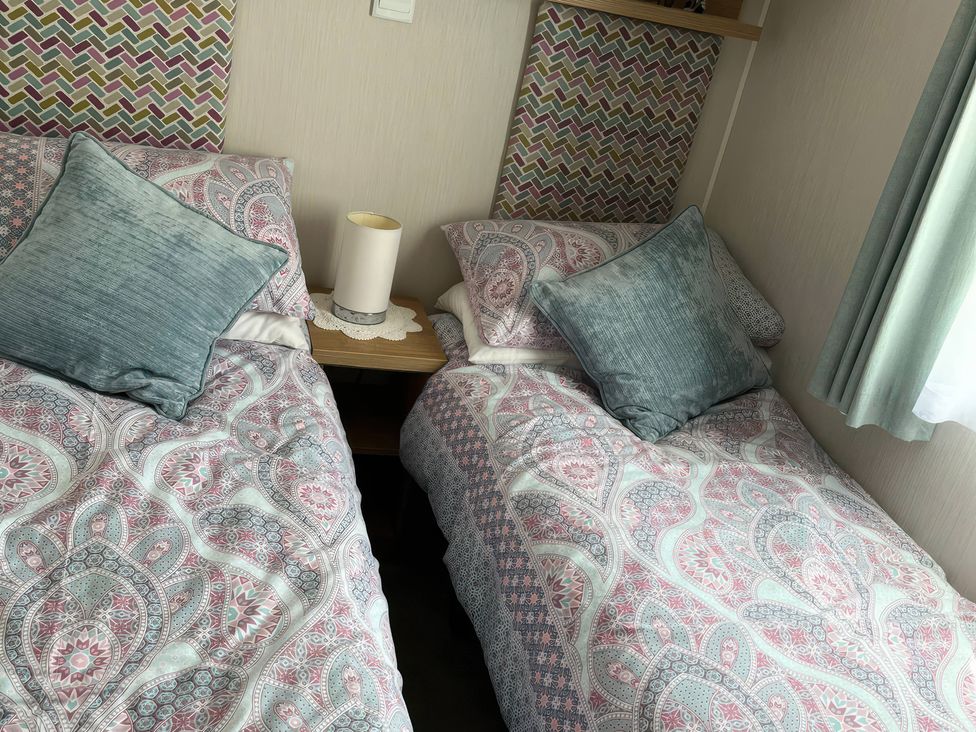 A bedroom with two beds and a bedside table at Freshwater Beach Holiday Park - Holiday Accommodation 17116, Burton Bradstock near Bridport