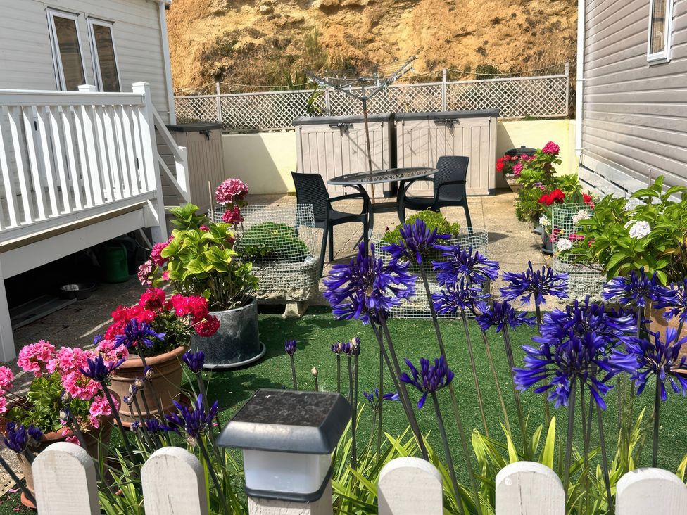 A garden with flowers and seating at Freshwater Beach Holiday Park - Holiday Accommodation 17116 near Burton Bradstock