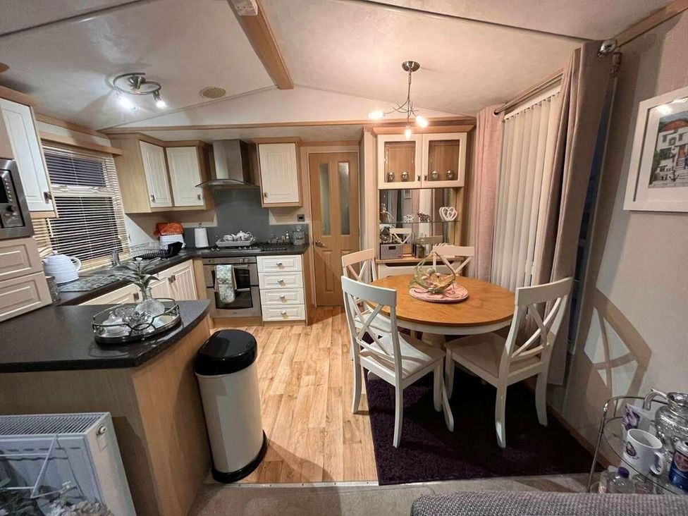 a kitchen and dining area with a table and chairs at Golden Anchor Holiday Park - Holiday Accommodation 17383 in Skegness
