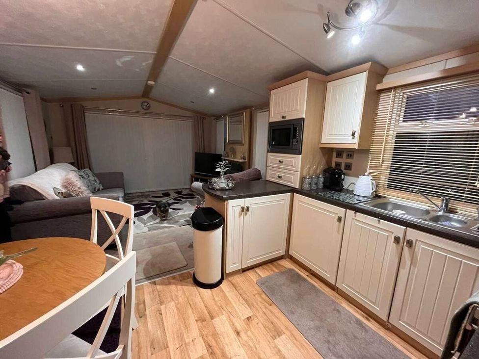 a kitchen and living area with a table and sofa at Golden Anchor Holiday Park - Holiday Accommodation 17383, Skegness