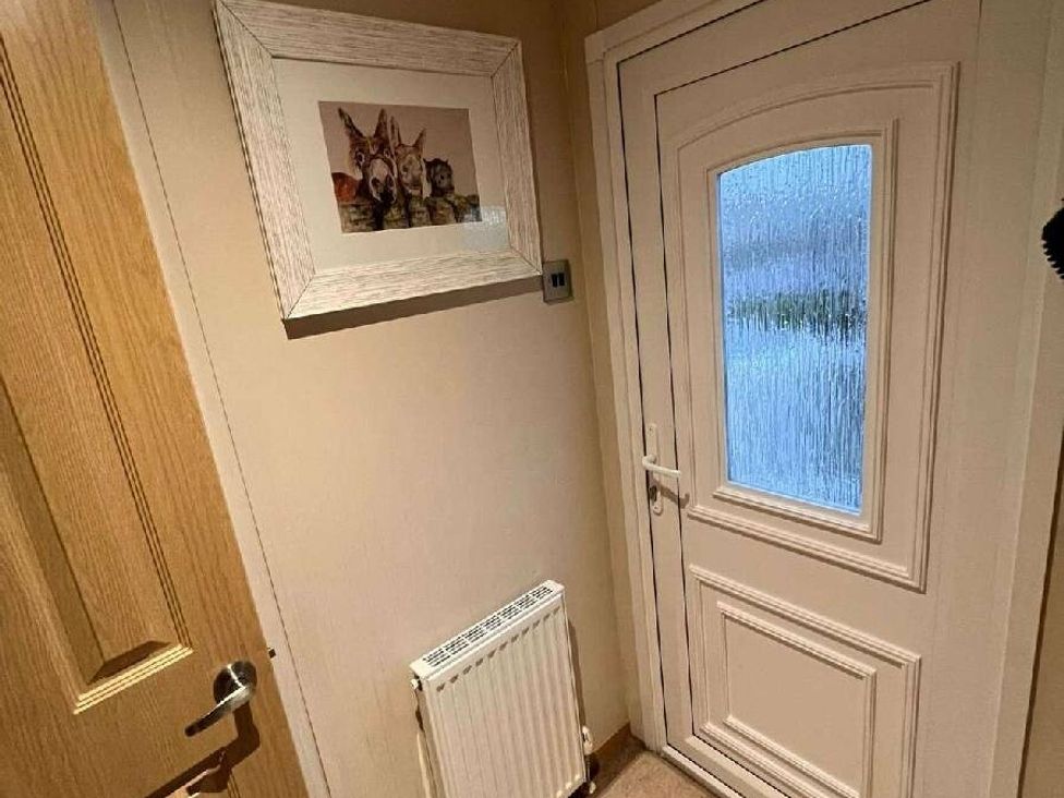 a hallway with a door and a framed picture at Golden Anchor Holiday Park - Holiday Accommodation 17383 in Skegness