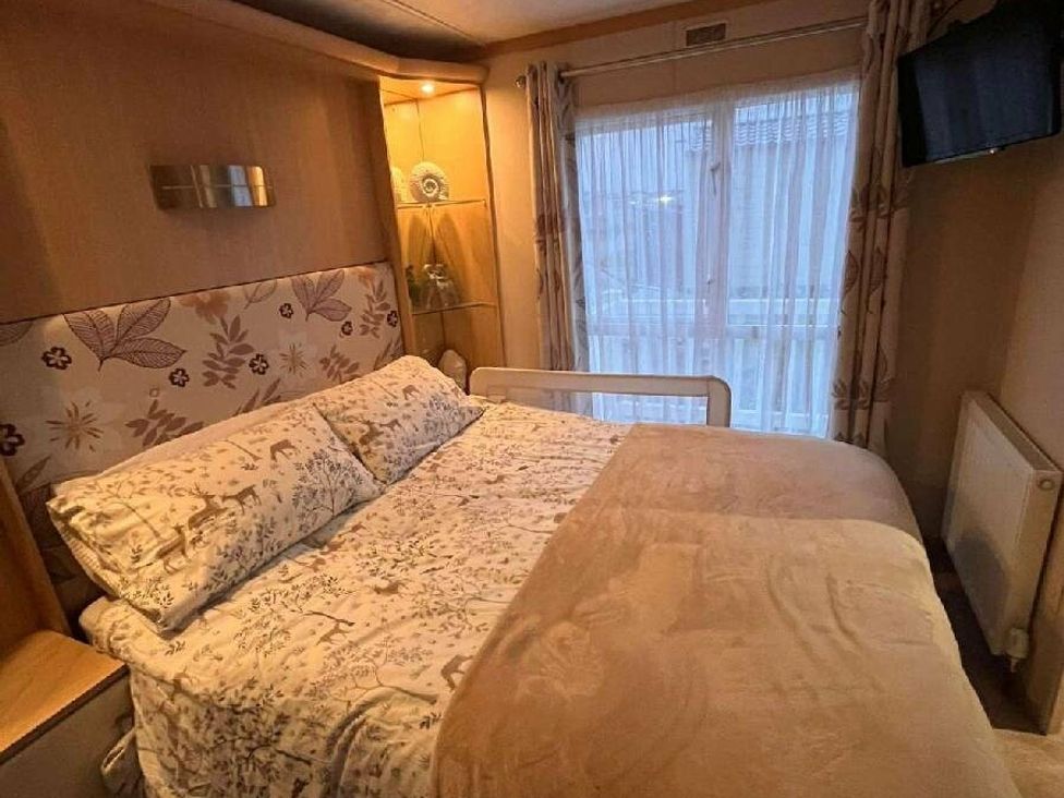 a bedroom with a double bed and a television at Golden Anchor Holiday Park - Holiday Accommodation 17383 in Skegness