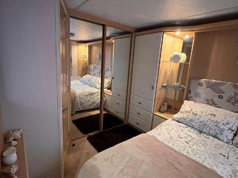 a bedroom with mirrored wardrobe and double bed at Golden Anchor Holiday Park - Holiday Accommodation 17383, Skegness