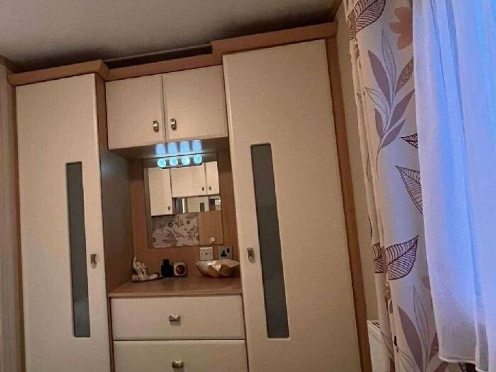 a wardrobe with a mirror and drawers at Golden Anchor Holiday Park - Holiday Accommodation 17383, Skegness