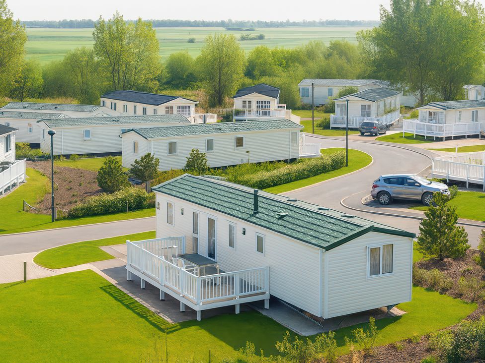 A mobile home with a deck in an outdoor area at Marton Mere Holiday Village - Holiday Accommodation 17890, Blackpool