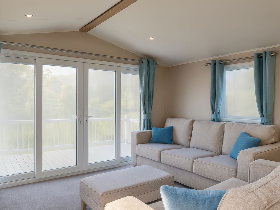 A living room with a sofa and glass doors at Marton Mere Holiday Village - Holiday Accommodation 17890 in Blackpool