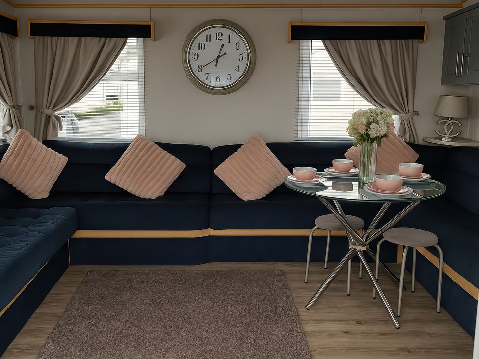 A living room with a sofa and table set at Millers Cottage Caravan Park - Holiday Accommodation 18845 Towyn, Abergele