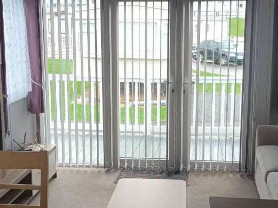 a room with sliding doors and vertical blinds at Golden Sands Holiday Park - Holiday Accommodation 18951 in Dawlish