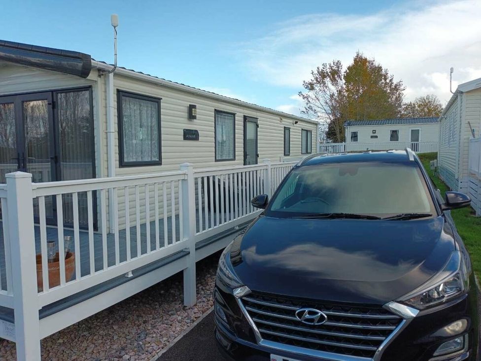 a mobile home with a black car parked in front at Golden Sands Holiday Park - Holiday Accommodation 18951 in Dawlish