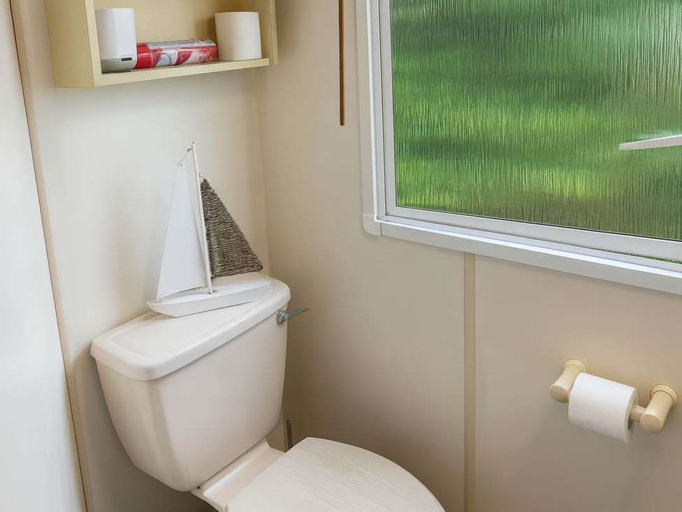 A bathroom with a toilet and decorative items at Brynowen Holiday Park - Holiday Accommodation 19041 Borth Mis Wales