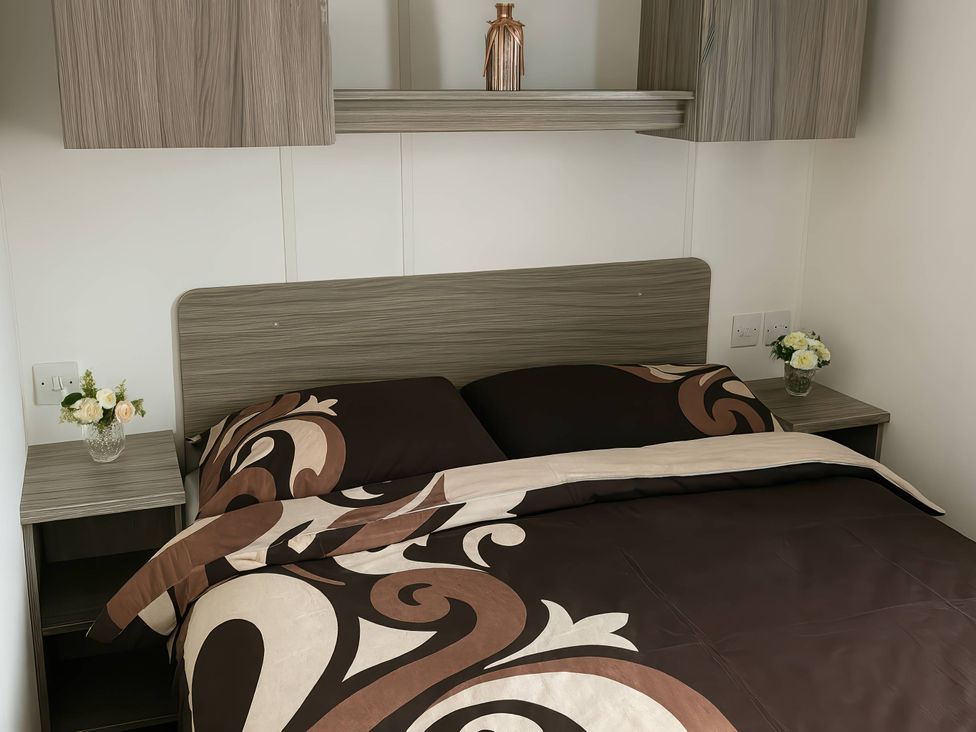 A bedroom with a bed and nightstand at Whitehouse Leisure Park - Holiday Accommodation 19055, Towyn, Abergele