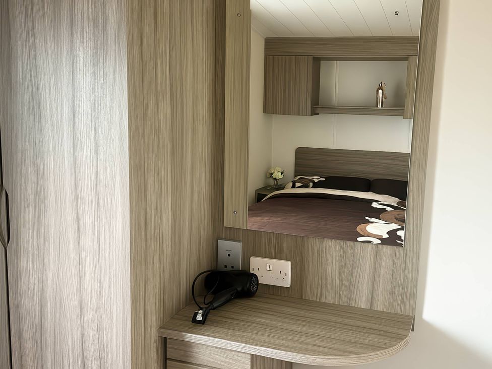 A bedroom with a mirror and hair dryer at Whitehouse Leisure Park - Holiday Accommodation 19055, Towyn, Abergele